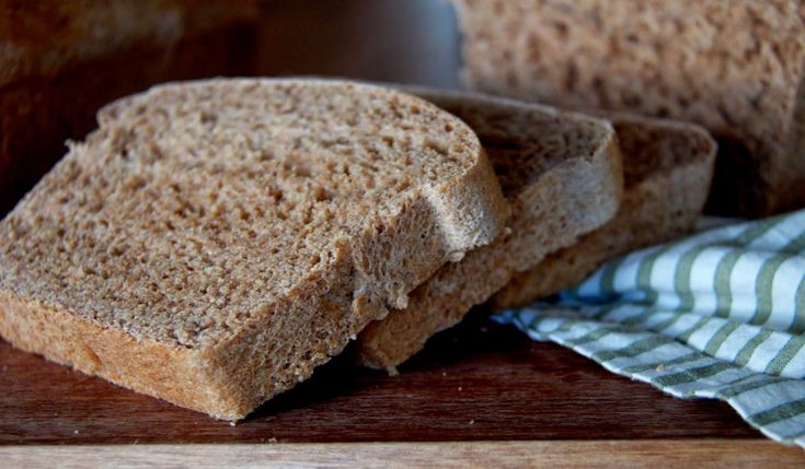 two pieces of bread sitting on top of a wooden cutting board