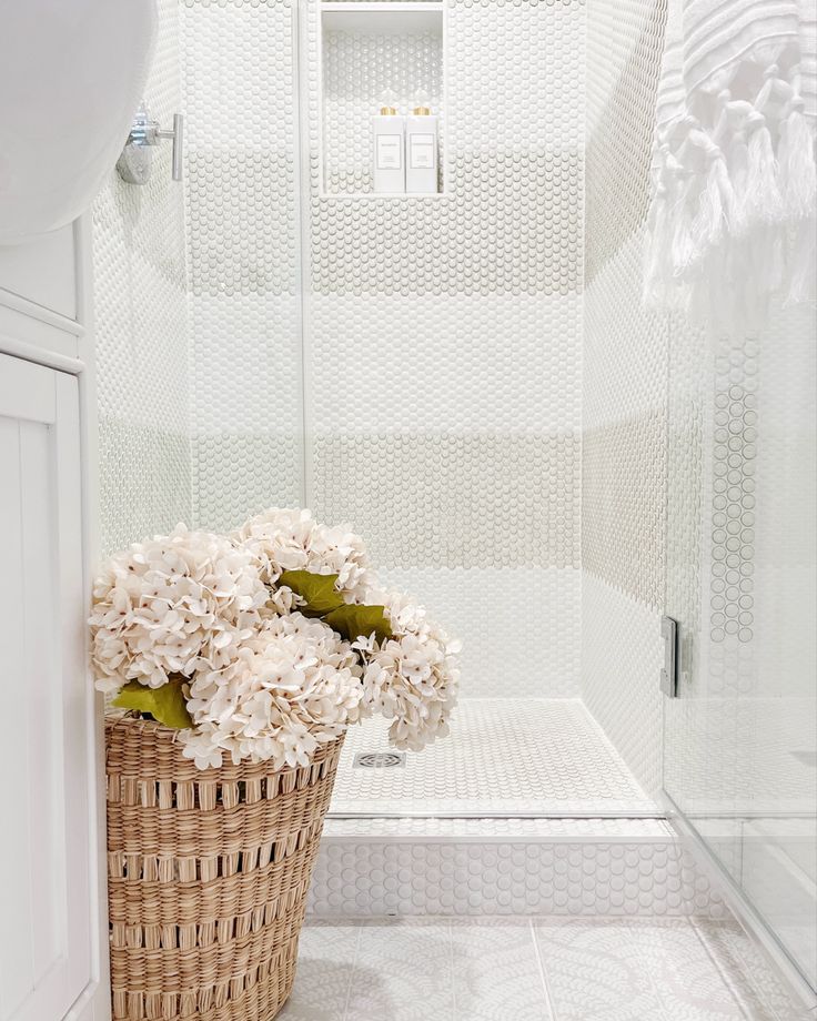 Coastal bathroom with beige and white striped shower, small white vanity, and basket of hydrangeas Striped Shower Tile, Mosaic Penny Tile, Fringe Bath Towels, Colonial Renovation, Shower Tile Ideas, Neutral Bathroom, Penny Tile, Small Vanity, Coastal Bathrooms