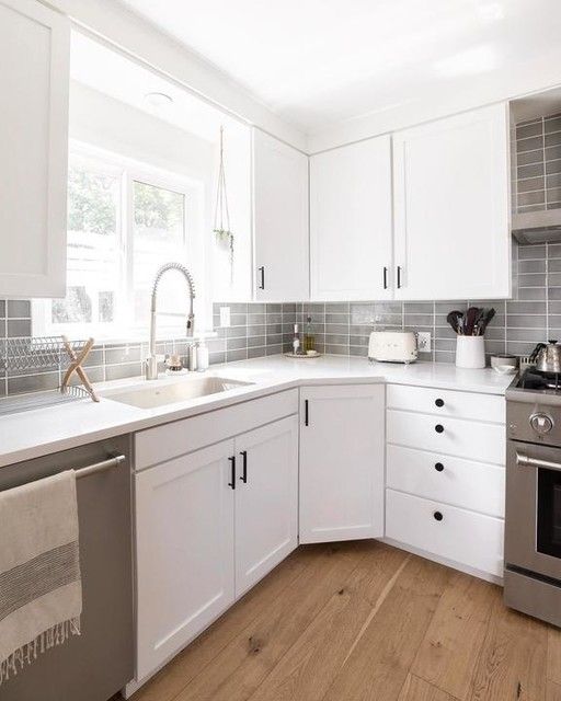 a kitchen with white cabinets and stainless steel appliances