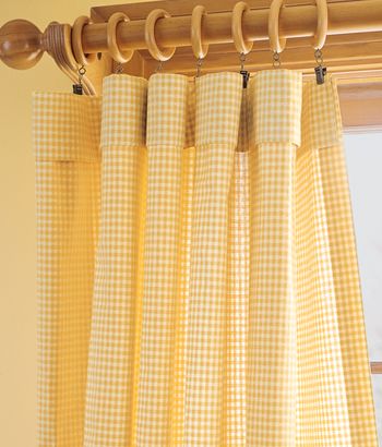 the curtains are hanging on the rod in front of the window with yellow gingham checkered fabric