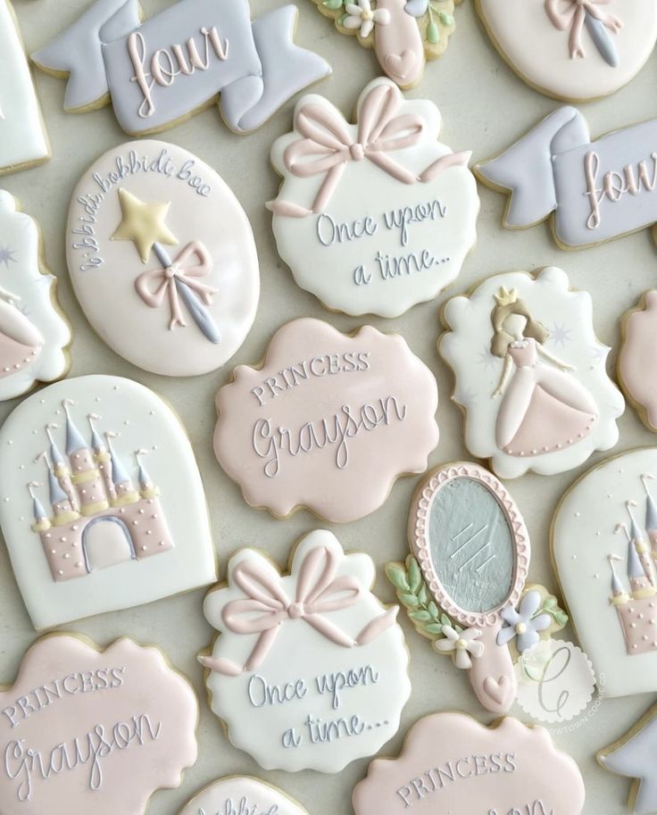 decorated cookies with princess sayings on them for a baby's first birthday party