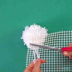 someone is using scissors to cut the mesh off of a piece of cloth with yarn