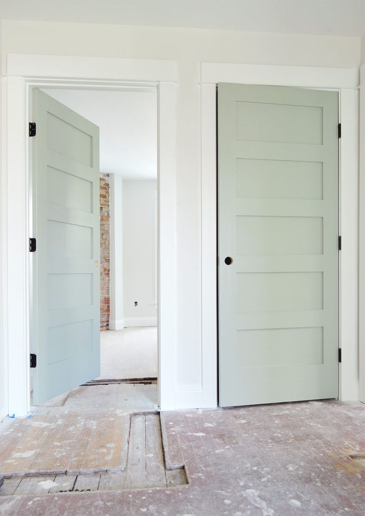 an empty room with two white doors and no one in the room is looking at it