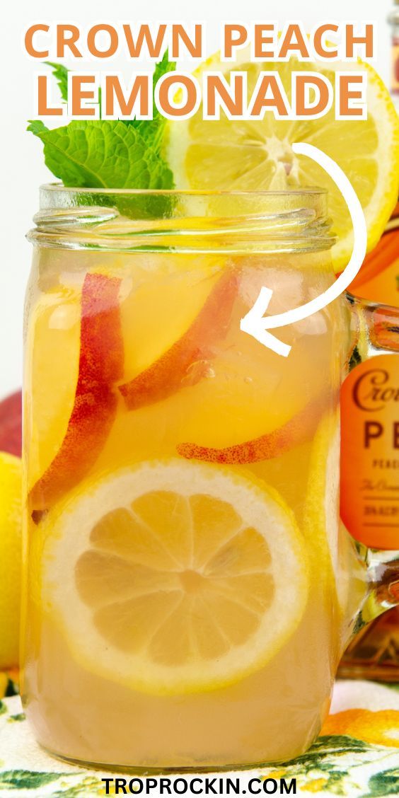 a mason jar filled with lemonade and sliced oranges next to a bottle of peach tea