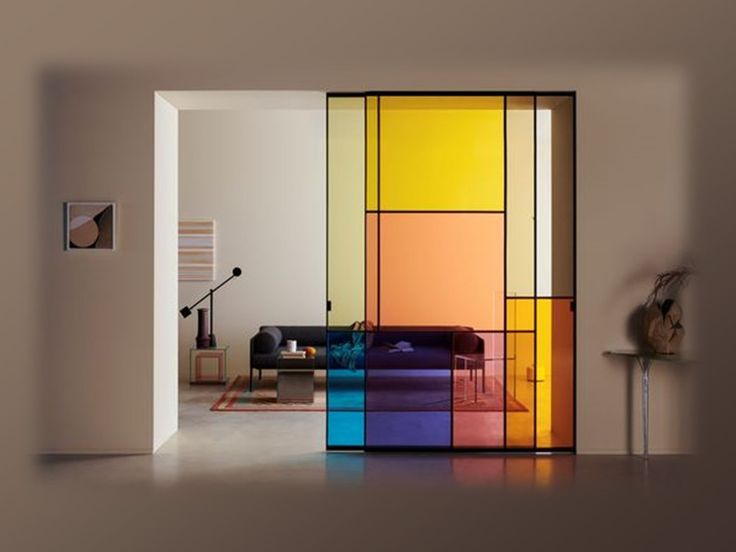 a living room with an open door that has multicolored glass panels on it