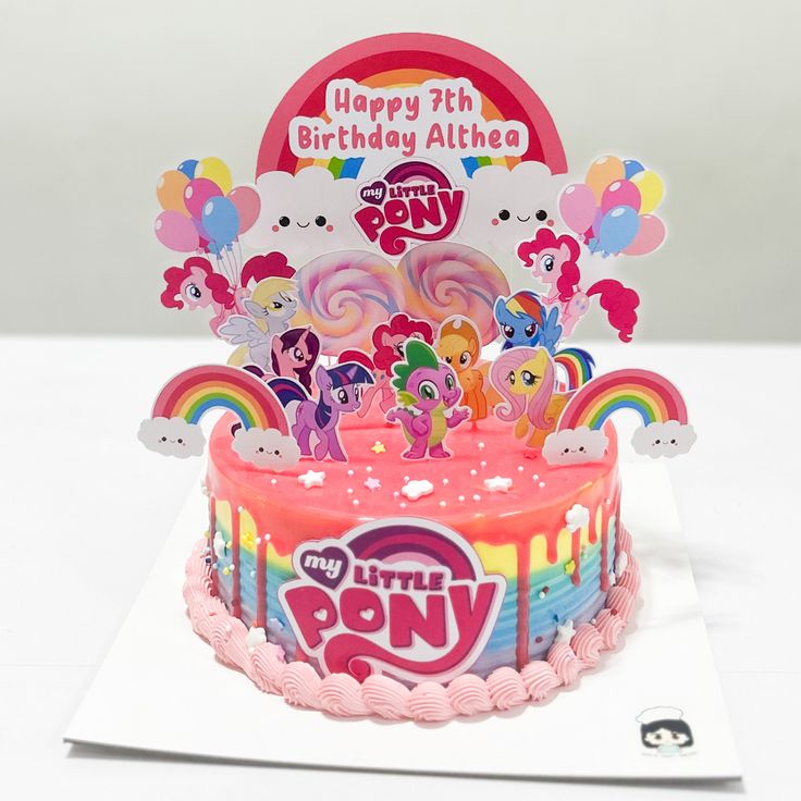 a birthday cake with pink frosting and lots of little pony characters on the top