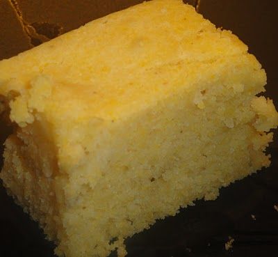 a piece of yellow cake sitting on top of a black plate