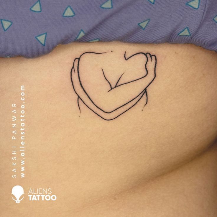 a woman's stomach with a small tattoo on the side of her belly, which is shaped like a heart