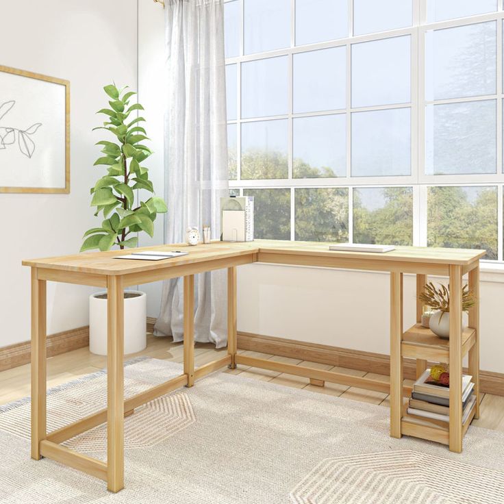 a computer desk sitting in front of a window next to a book shelf and potted plant