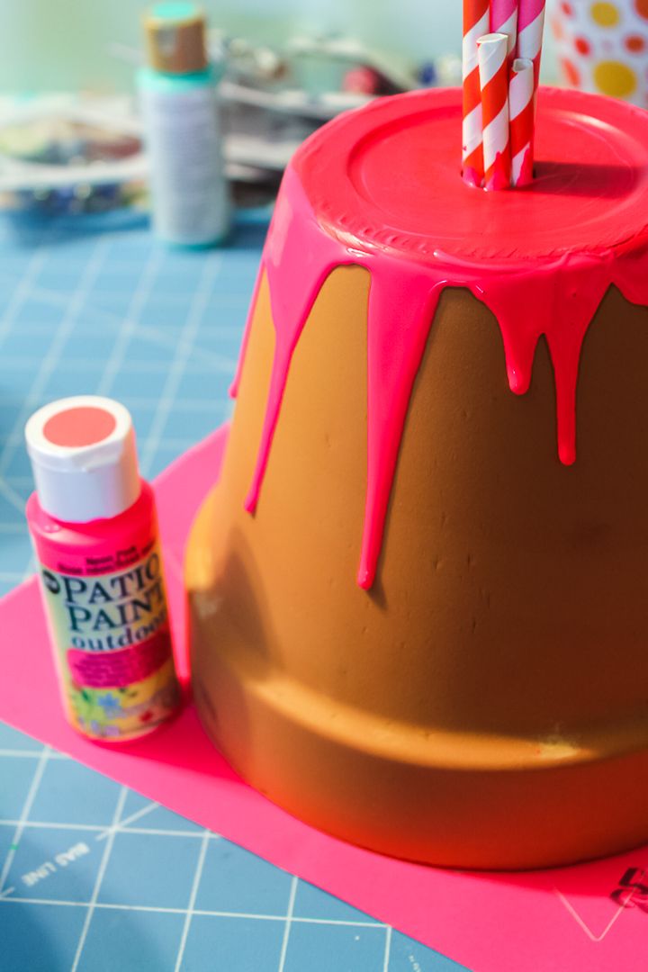 a cake with pink icing and two candles sticking out of it's top