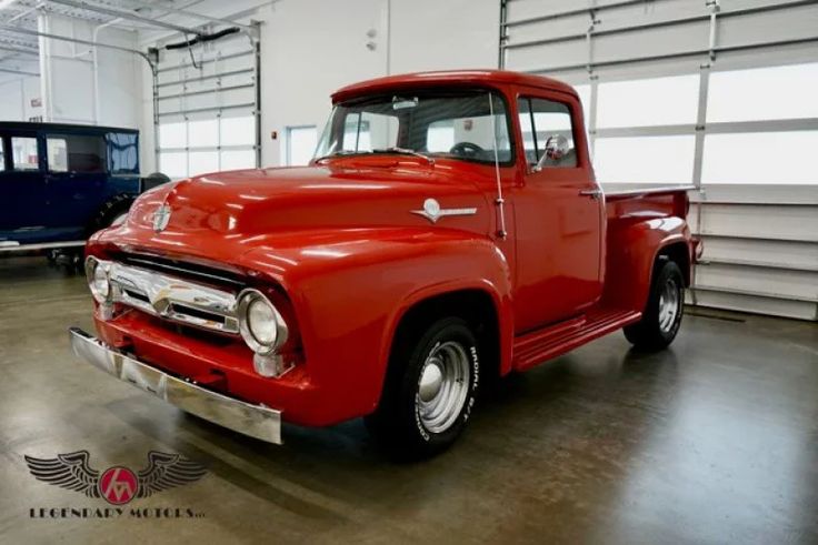 an old red truck parked in a garage