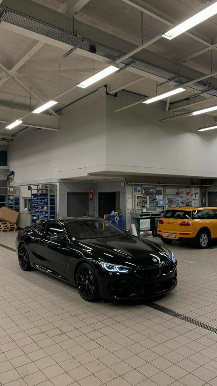 two cars are parked in a garage near each other