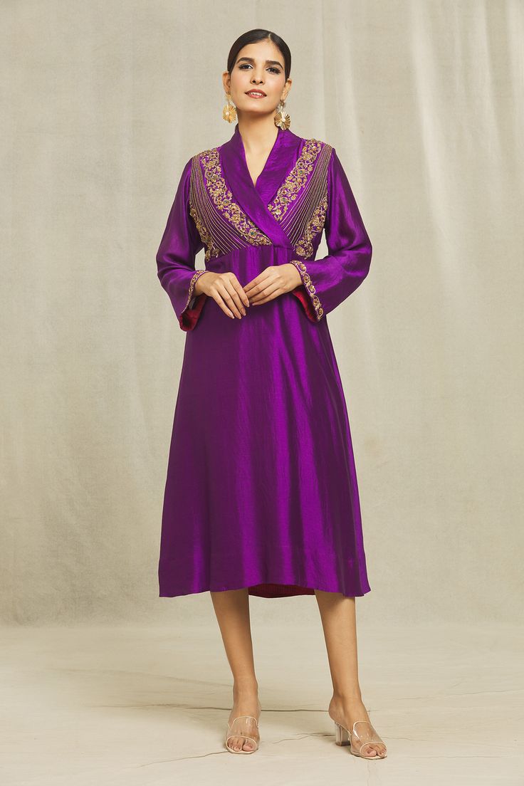 Purple dress kurta in organic silk base with bells sleeves, shawl collar, floral motifs, zardozi, sequins, beads, cutdana, kasab, resham and cotton thread hand embroidery. Comes with a matching mask.
Components: 2
Pattern: Hand Embroidered
Type Of Work: Floral
Neckline: Shawl Collar
Sleeve Type: Bell
Fabric: Organic silk
Color: Purple
Occasion: Mehendi and Haldi - Aza Fashions Festive V-neck Dress With Resham Embroidery, Traditional V-neck Embroidered Wedding Dress, Festive V-neck Kurta With Zari Work, Long Sleeve Embroidered Dress With Zari Work For Reception, Festive V-neck Kurta For Party, Traditional Embroidered V-neck Dress For Eid, V-neck Traditional Wear For Eid, Elegant V-neck Kurta For Festive Occasions, Traditional Long Sleeve Embroidered Dress For Reception