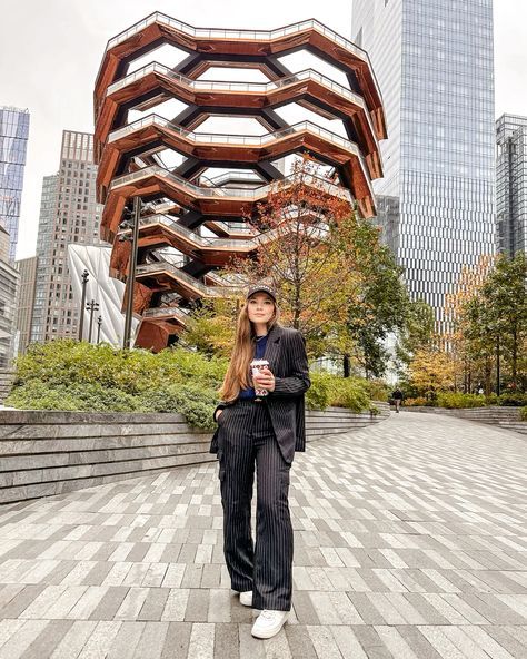 a woman standing in front of a tall building