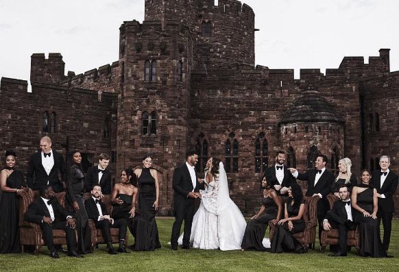 a large group of people posing for a photo in front of a castle like building