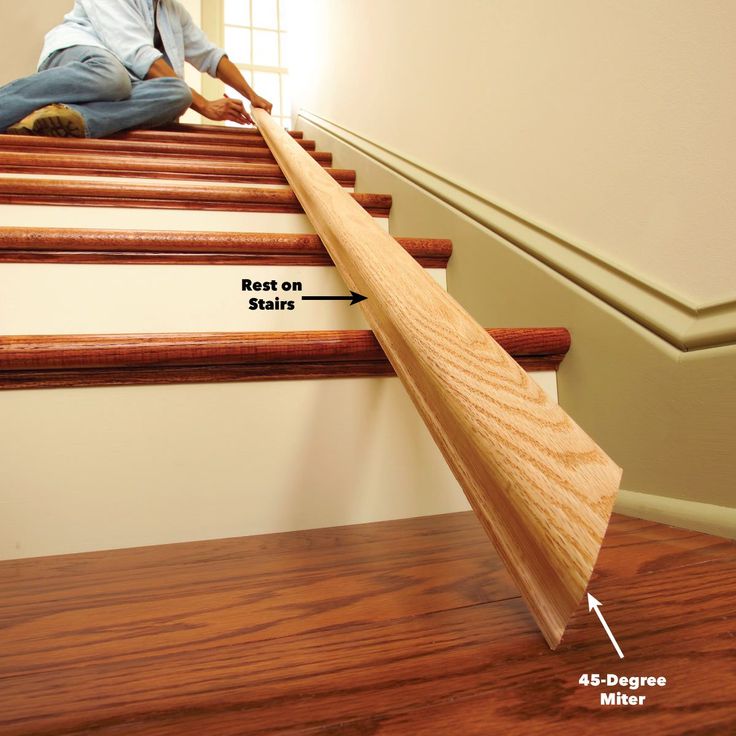 a man sitting on top of some stairs with a wooden stick in his hand and pointing at the floor