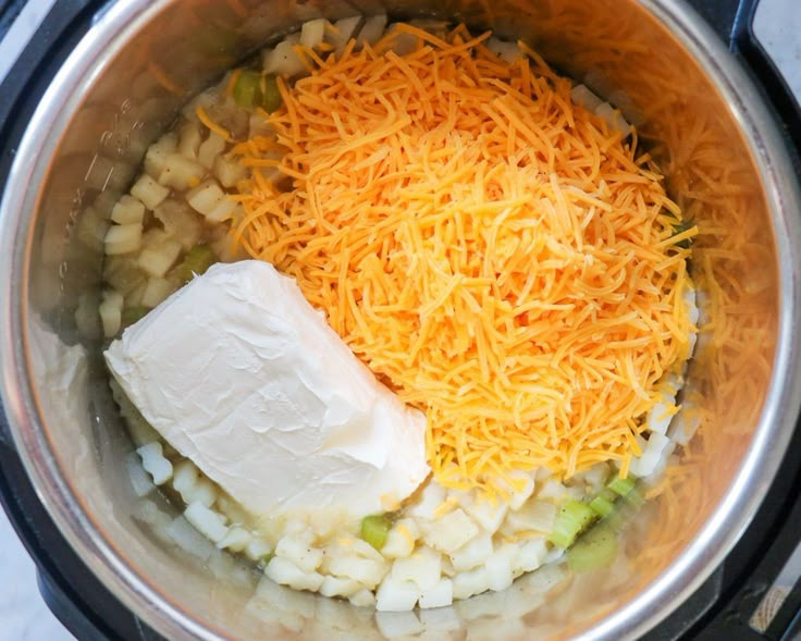 the food is being prepared in the crockpot with cheese and broccoli