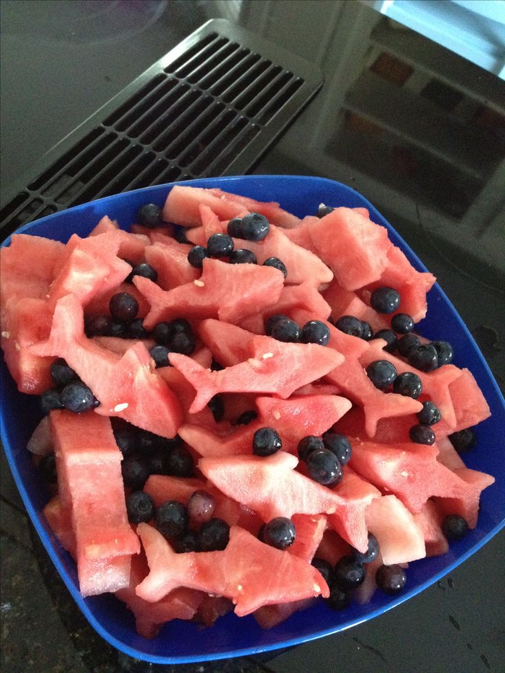 a blue bowl filled with watermelon and blueberries on top of a counter