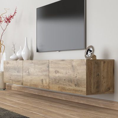 a flat screen tv mounted to the side of a wooden entertainment center in a living room