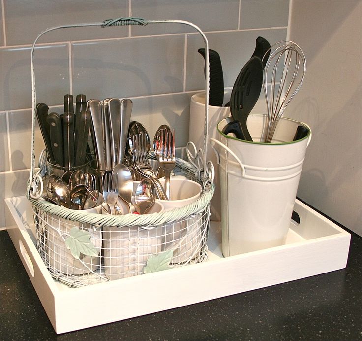 a white basket filled with silverware and utensils