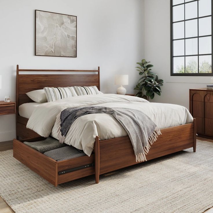 a bed sitting in a bedroom next to a dresser with drawers on top of it