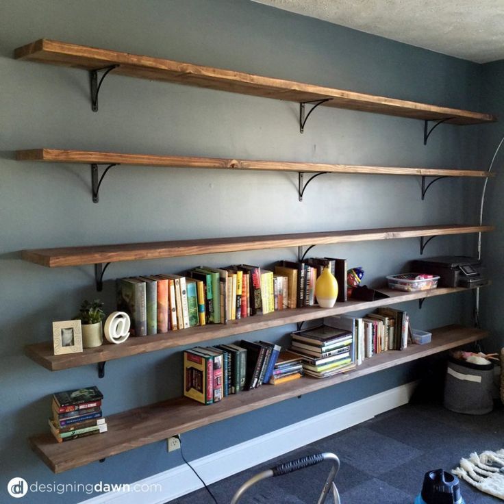 some bookshelves are lined up against the wall in a room with blue walls