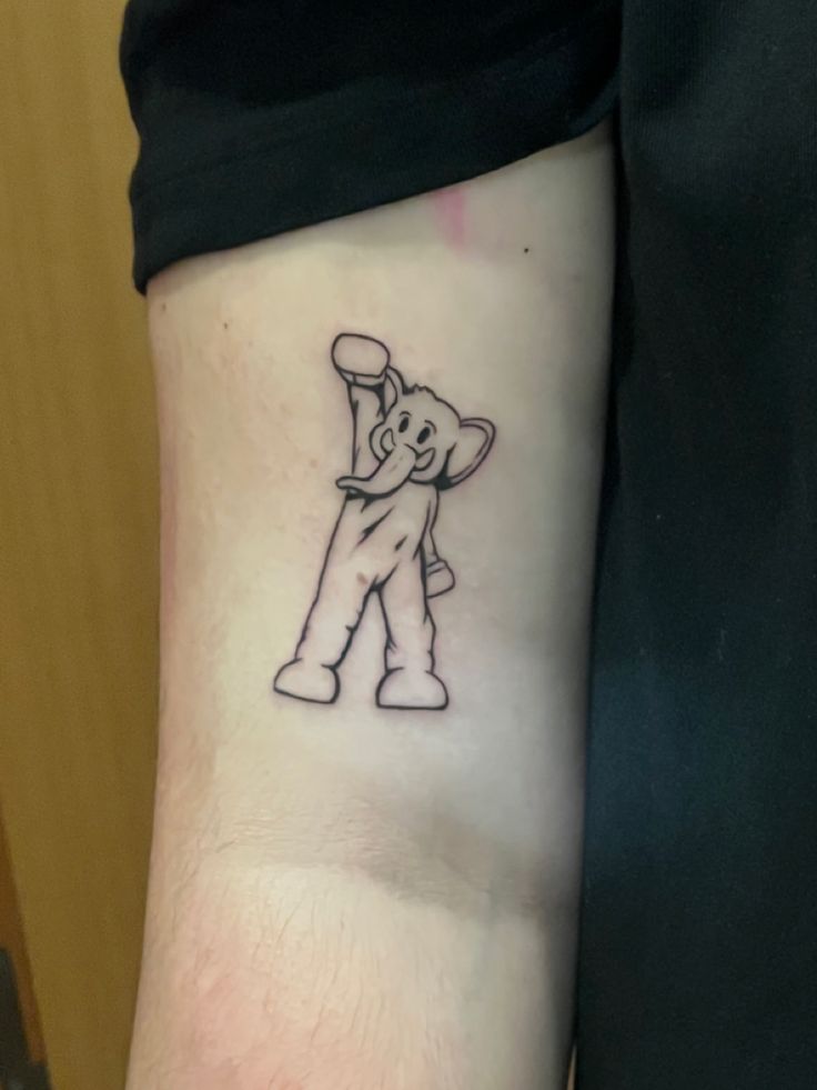 a person with a tattoo on their arm that has an elephant holding a baseball bat