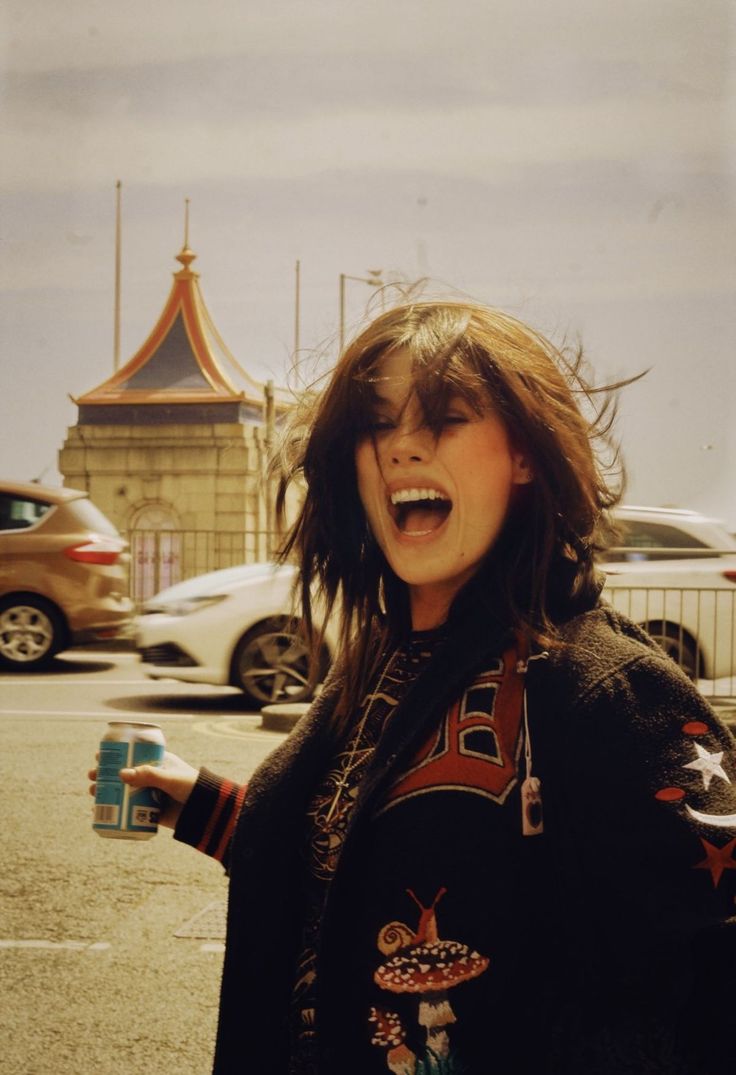 a woman standing in the middle of a parking lot with her mouth open and tongue out