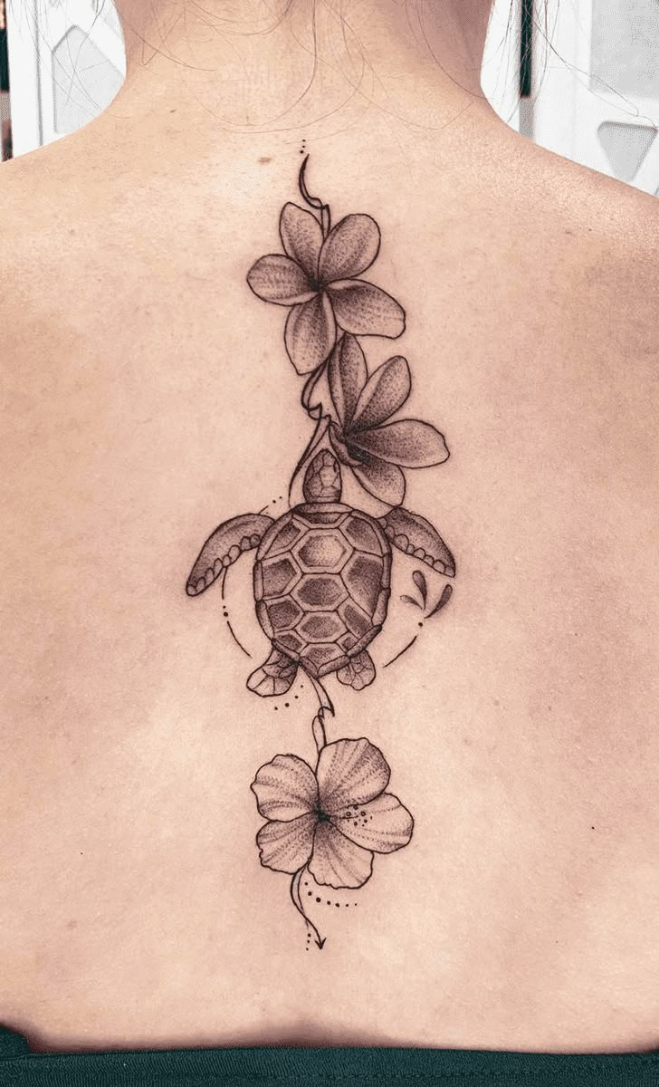 a woman's back with a turtle and flowers on it