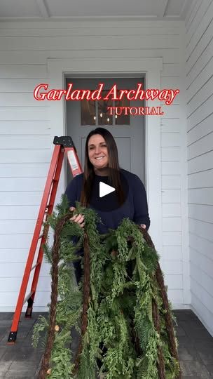 a woman standing in front of a doorway with a ladder and christmas wreath on it