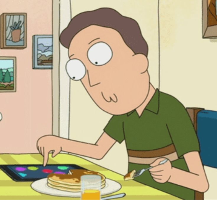 a man sitting at a table in front of a plate of food with pancakes on it