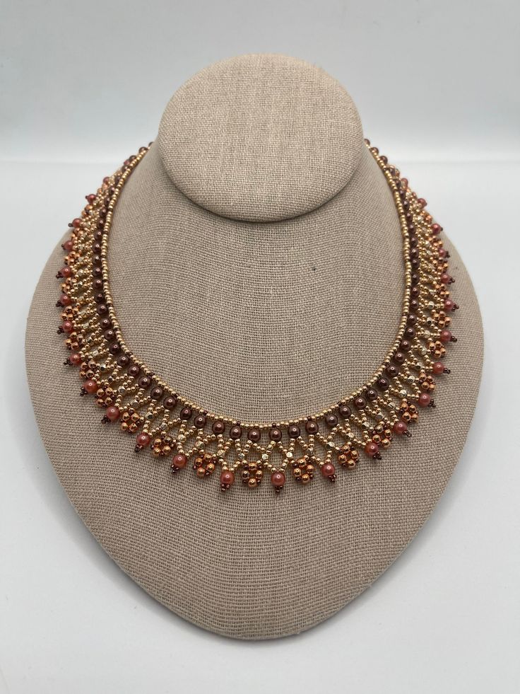 This handmade women's rose gold necklace is made with bronze and various shades of rose gold beads, including rose gold seed beads.  It closes with a rose gold toggle clasp. It is lightweight and compliments most attire. Elegant Copper Beaded Necklace For Gift, Handmade Copper Beaded Necklaces With Round Beads, Elegant Brown Beaded Necklace With Spacer Beads, Elegant Copper Beaded Necklaces For Gifts, Elegant Handmade Rose Gold Beaded Necklaces, Rose Gold Necklaces With Round Tiny Beads, Elegant Rose Gold Necklaces With Faceted Beads, Elegant Brown Round Beaded Necklace, Handmade Copper Beaded Necklaces