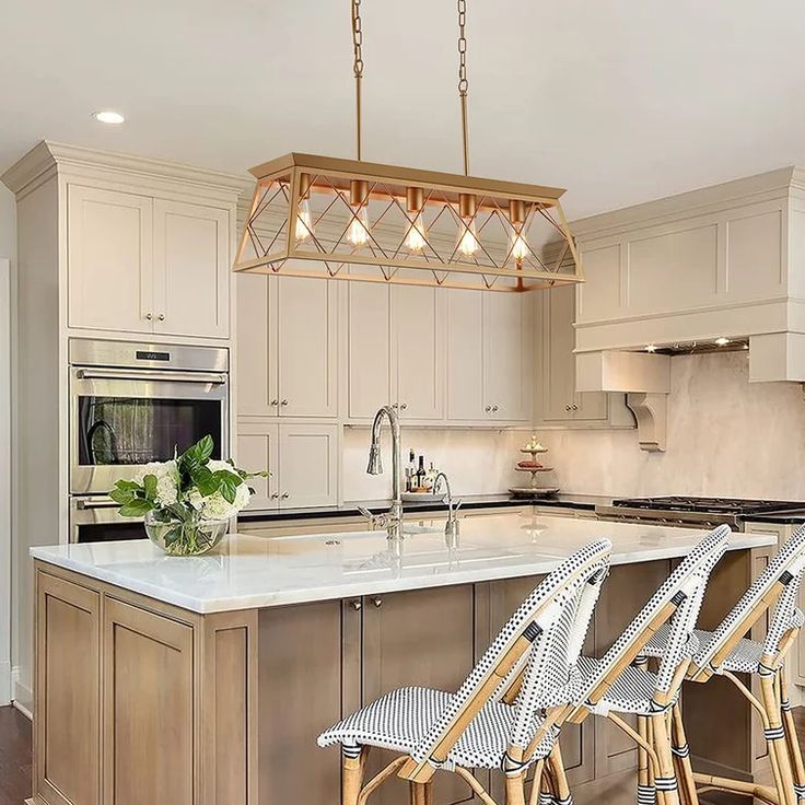 a kitchen with an island and four stools in front of the countertop area