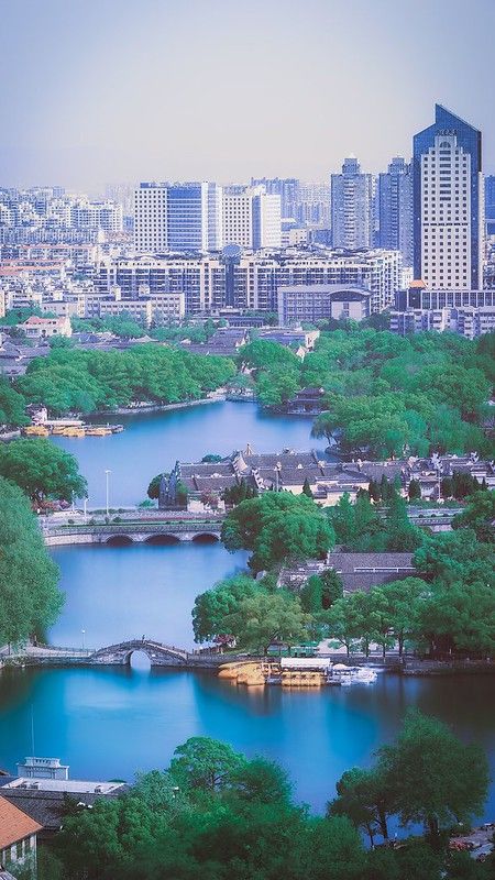 the city is surrounded by trees and water