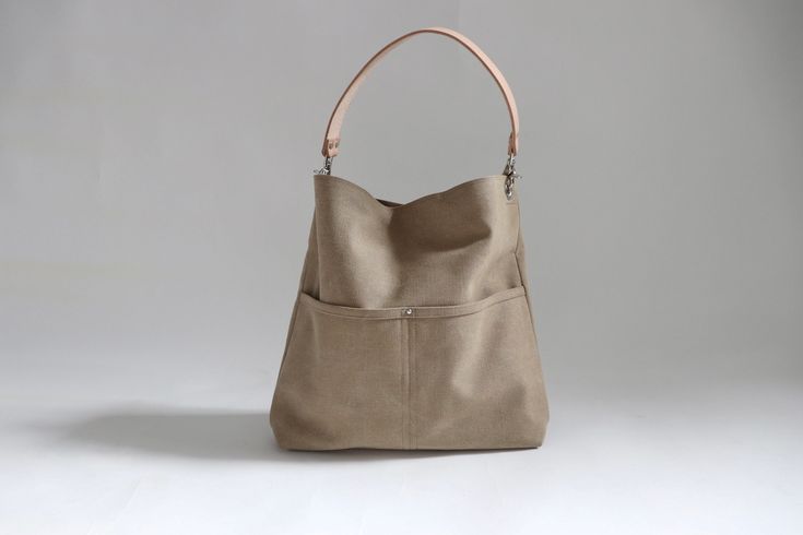 The best tote bags combine casual style with useful functionality in an easy to carry shape. Our canvas hobo bag gets it all just right.  Modern and minimalist with lots of pockets in all the right places.   Plenty of interior space with just the right amount of slouch so the bag never feels too big. Durably handcrafted with attention to detail in the perfect neutral khaki color that goes with everything. This listing is for the Large size as pictured.  More sizes and colors available in my Shop Chic Everyday Bucket Bag With Pockets, Everyday Hobo Bag With Pockets, Everyday Canvas Bucket Hobo Bag, Khaki Canvas Hobo Shoulder Bag, Modern Hobo Shoulder Bag With Pockets, Leather Canvas Bag With Pockets For Everyday Use, Chic Everyday Hobo Bag With Pockets, Khaki Canvas Hobo Bag Tote, Modern Hobo Bucket Bag For Everyday