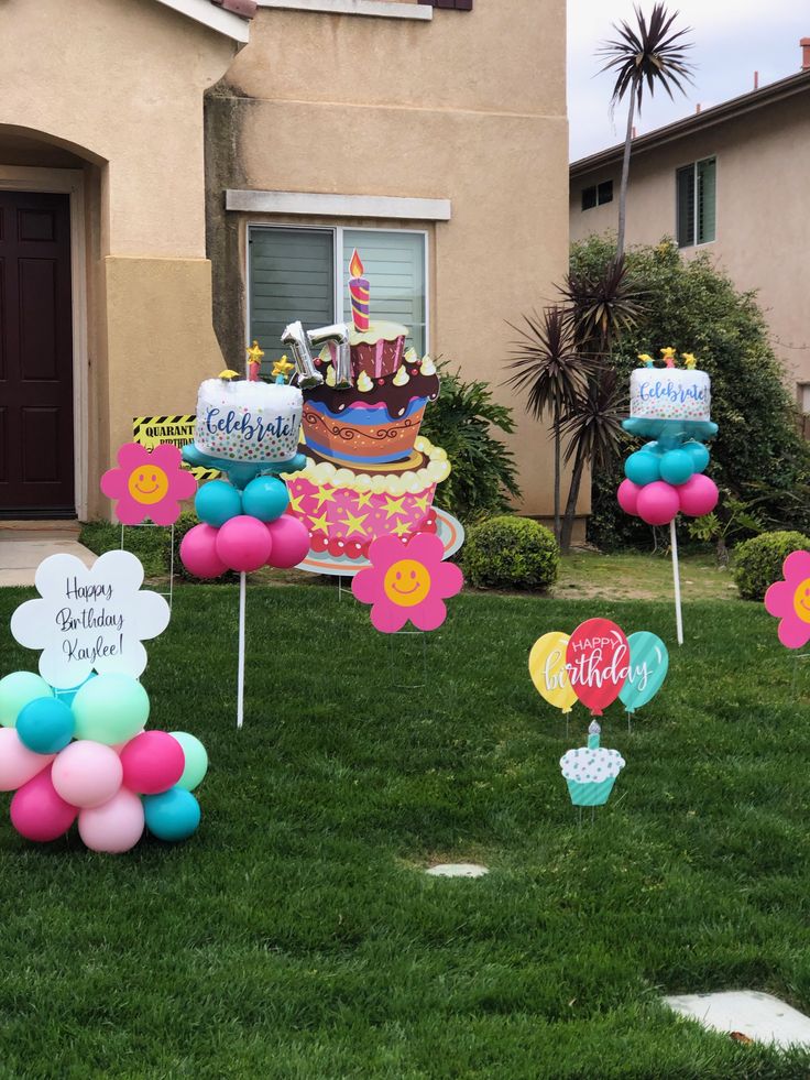 birthday decorations in front of a house with balloons and cake on the lawn for children's birthday party