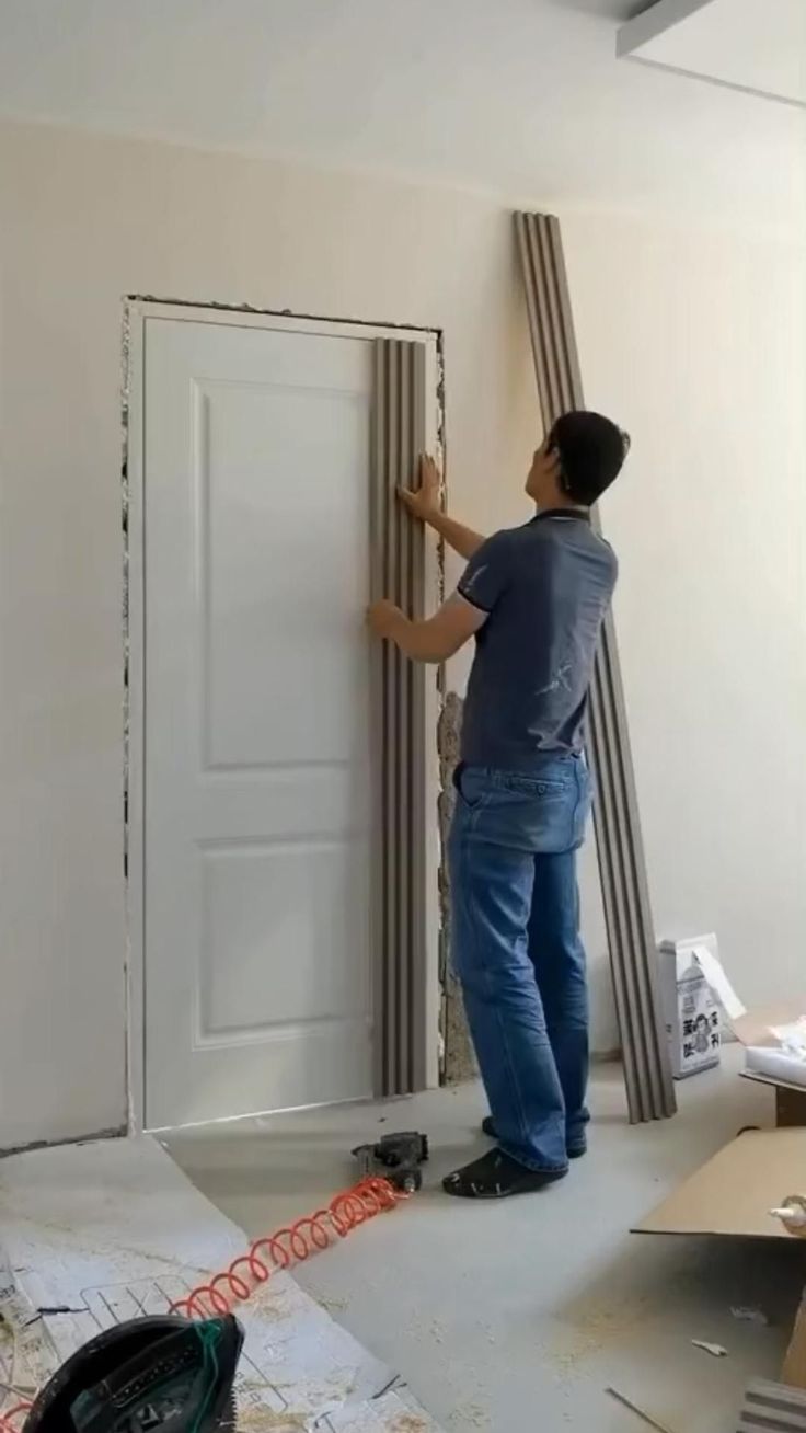 a man that is standing in front of a door with some tape on the floor