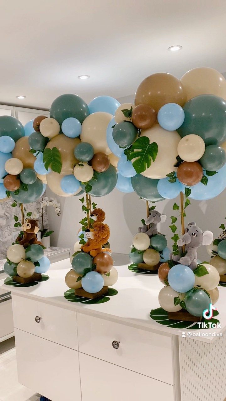 balloons are arranged in the shape of animals and plants on display at a party or baby shower