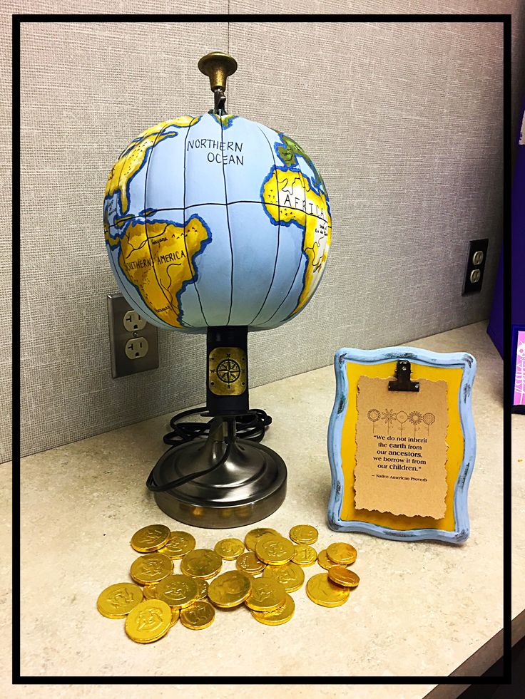 a globe and some gold coins on a counter