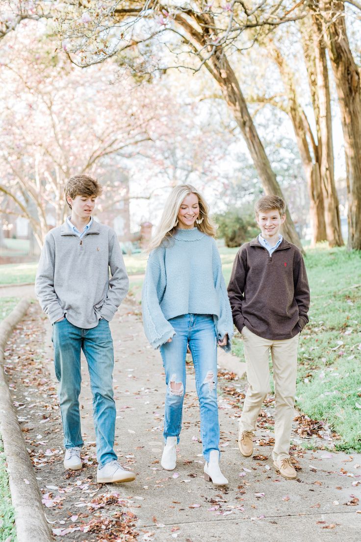 two boys and a girl walking down a path