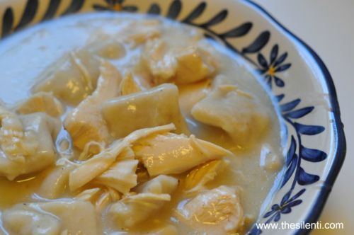 a bowl filled with dumplings and sauce on top of a table