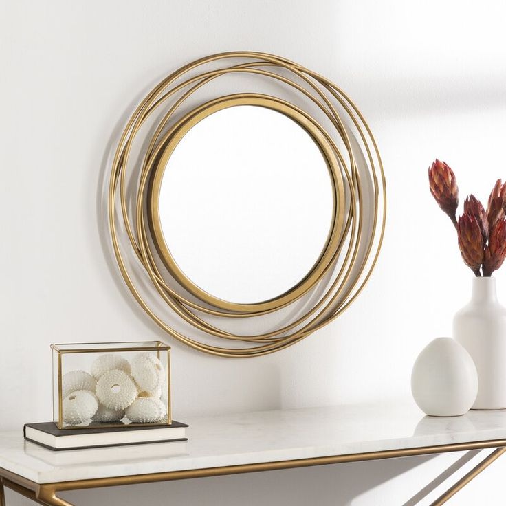 a white table topped with a mirror and vase filled with flowers