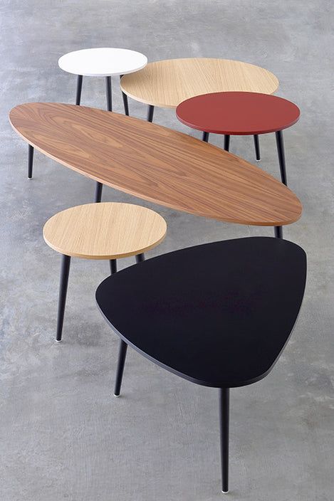 four tables with different colors and shapes on them, one is black, the other is white