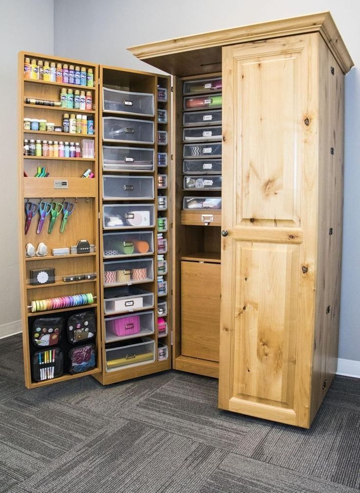 a large wooden cabinet with many drawers and items in it's bottom section, open to reveal the contents inside