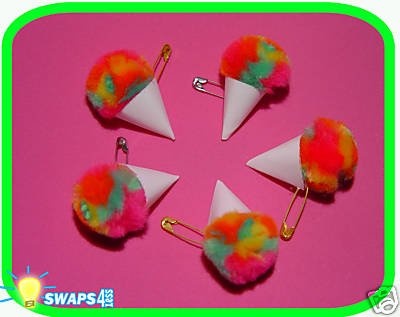 four different colored pom poms on a pink background