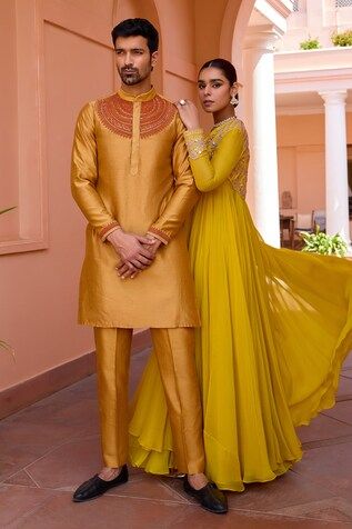 a man and woman standing next to each other in formal wear, posing for the camera