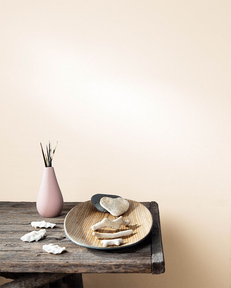 a wooden table topped with a plate filled with food next to a vase full of flowers