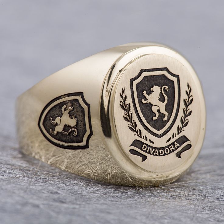 "This signet ring is crafted from 14K solid yelow gold and has a substantial feel to it with a designer quality finish. We can engrave your family crest on the top and sides of the ring and use our unique hand-crafted black finish to add contrast. We can also help you design a unique family crest using your choice of shield, symbols and text for an additional fee (please contact us for design pricing). ITEM DETAILS Item# SRGC006-FC Metal: 14K Solid Gold ITEM DIMENSIONS Width Widest Point: 18.23m Luxury Engraved Ring With Coat Of Arms For Gift, Luxury Oval 14k Stamped Signet Ring, Luxury Oval Signet Ring Stamped 14k, Luxury Oval Signet Ring With Polished Finish, Personalized Yellow Gold Signet Ring Collectible, Luxury Oval Signet Ring, Luxury Oval White Gold Signet Ring, Luxury Round Signet Ring With Hallmarks, Classic Personalized Signet Ring For Collectors