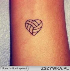 a small tattoo on the wrist of a woman with a heart shaped knot in it