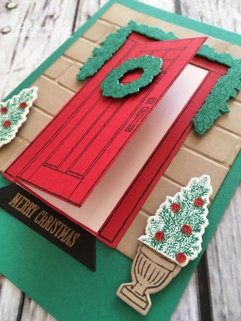 a handmade christmas card with a red door and green trimmings on it